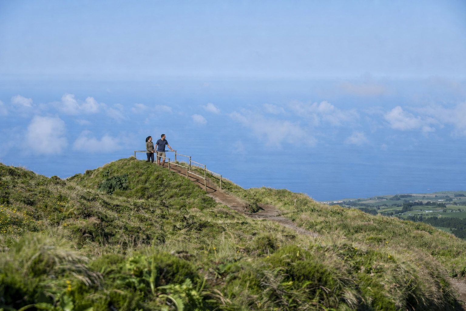Casal num trilho dos Açores com o Atlântico ao fundo